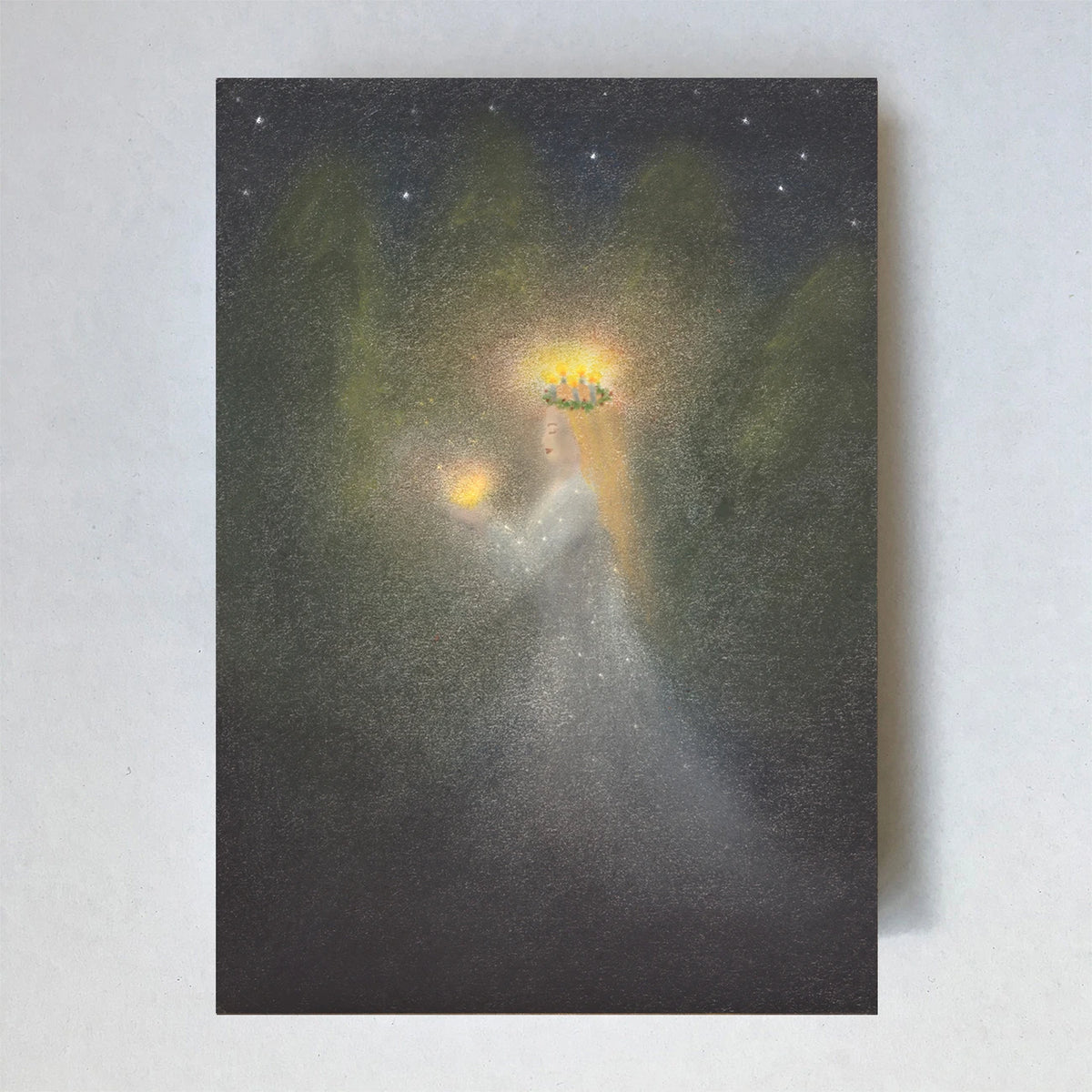 Postkarte St. Lucia von Lot Bouwes A6: Lucia mit Lichterkranz auf dem Kopf und Kerze in der Hand im weißen Kleid im dunklen Wald