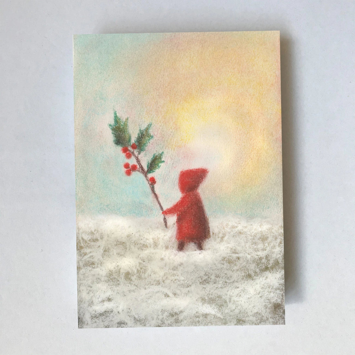 Postkarte Stechpalme von Lot Bouwes A6: ein Wichtel in Rot trägt einen Stechpalmenzweig mit roten Beeren durch den Schnee