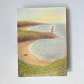 Postkarte Strand von Lot Bouwes A6: Küste mit Sandbucht, rot-weißer Leuchtturm auf der Landzunge, ein Boot am Strand, gelbe Blumen im Vordergrund