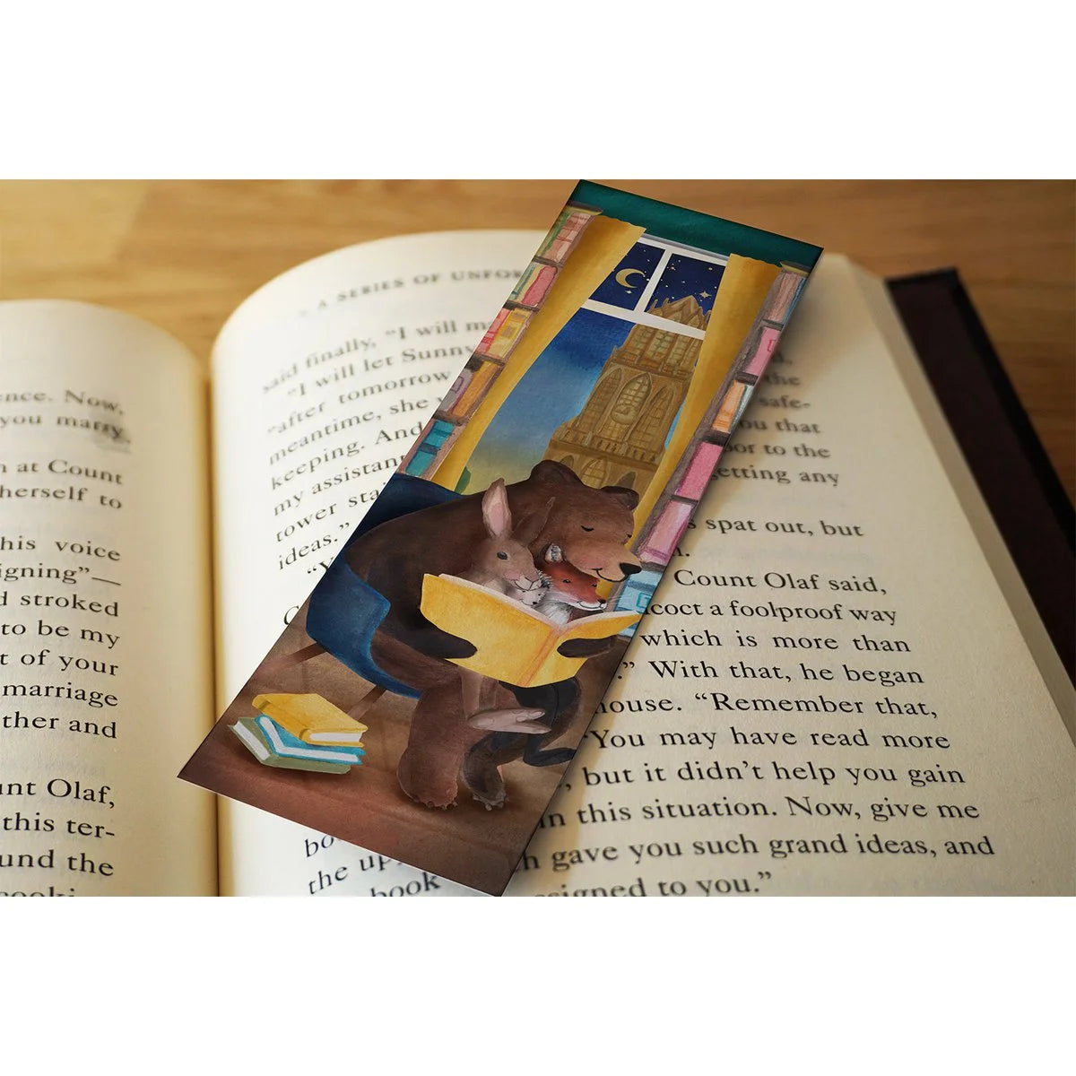 Lotte Drouen Lesezeichen Buch lesen, Bär, Hase und Fuchs lesen zusammen im Sessel vor Bücherregalen und einem Fenster mit Mond, auf einem aufgeschlagenen Buch