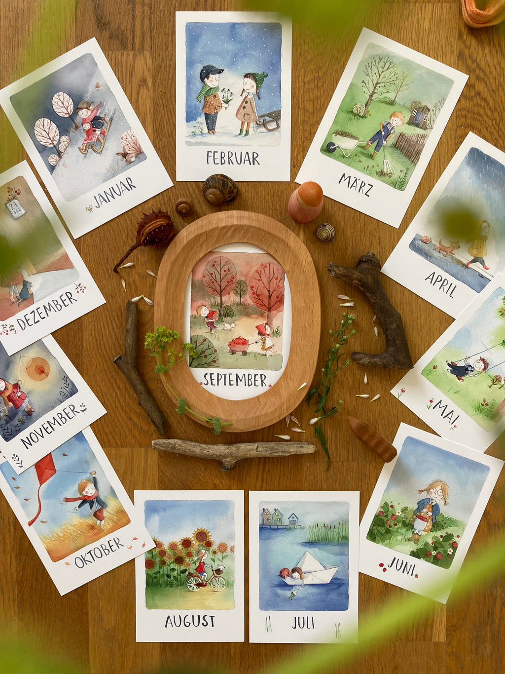 Monatskarten-Set von Stefanie Messing, alle zwölf Karten auf einem Holztisch ausgelegt, Foto