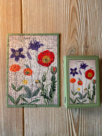 Minipuzzle Wildblumen-Archiv von Penny Puzzle 99 Teile, fertig gepuzzelt neben der Schachtel