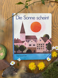 Pappbilderbuch Die Sonne scheint von Hilde Heyduck-Huth 2. Hand, Cover mit Kirchturm, Häusern und roter Sonne, Foto