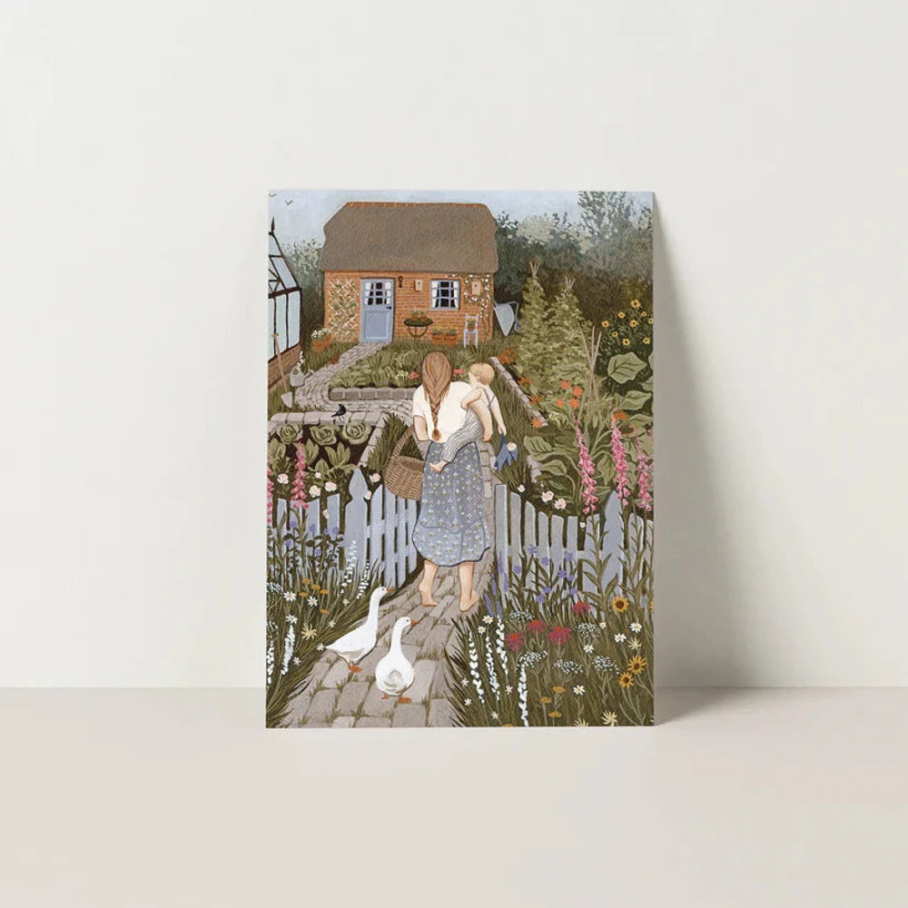 Postkarte Juni von Robin Pieterse A6: eine Mutter trägt ihr Kind durch das Gartentor in einen blühenden Bauerngarten, Gänse laufen hinterher