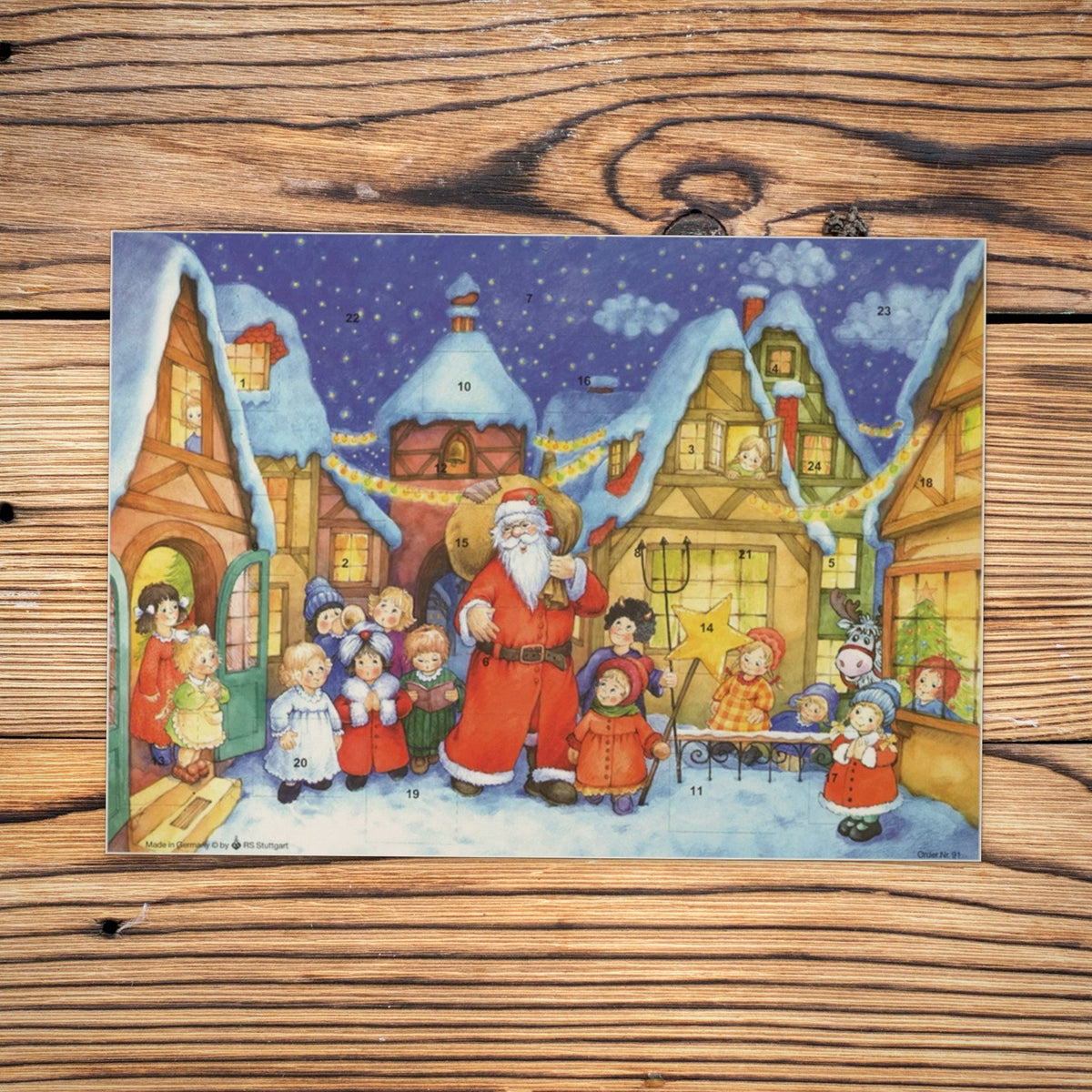 Sellmer Adventskalender Der Weihnachtsmann kommt in die Stadt A4 auf einem Holztisch