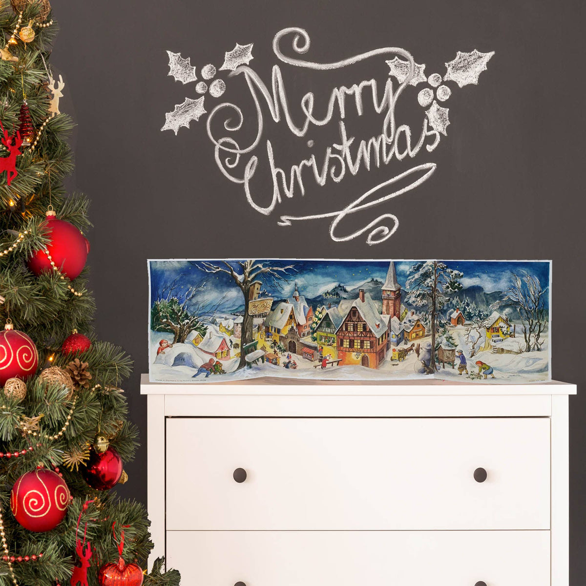 Panorama-Adventskalender Kleines Dorf im Winter von Sellmer, aufgestellt auf einer Kommode