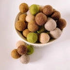 Filzkugeln Dinofarben 2 cm von Sewing Seeds Play in Braun, Grün, Beige und Rosa in einer Schale