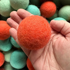 Große Filzkugel 6 cm von Sewing Seeds Play in einer Hand