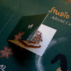 Adventskalender Wichtel von Studio Satsch, geöffnetes Türchen mit kleinem Lebkuchenhaus