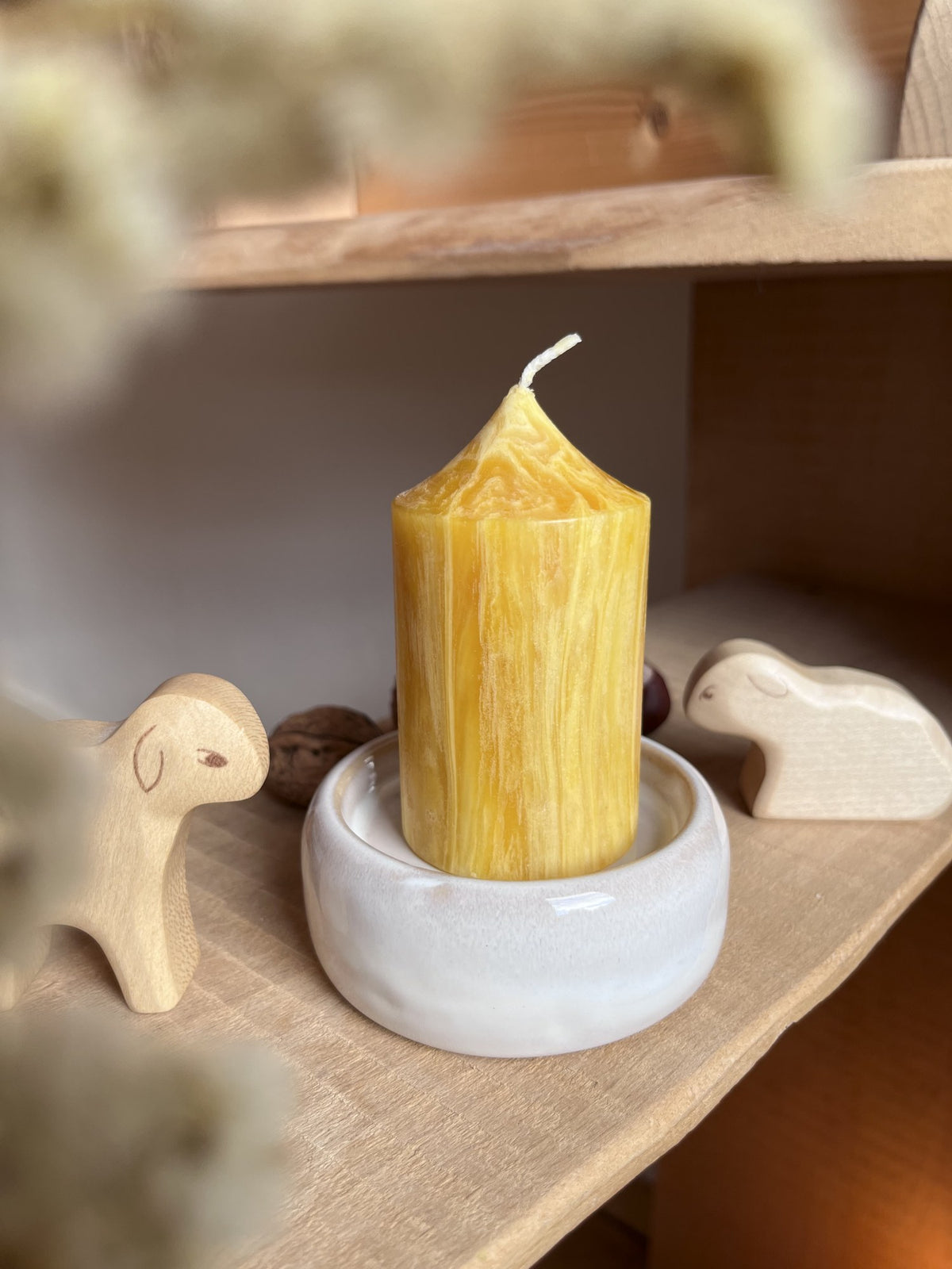 Kleine Stumpenkerze aus Bienenwachs auf dem kleinen Kerzenteller aus Keramik