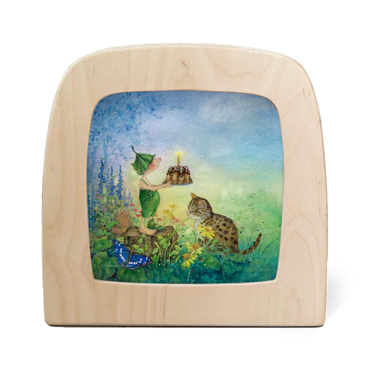 Toverlux Motiv Giesbert mit Kuchen von Daniela Drescher in der magischen Lampe: Wichtel Giesbert mit einem Kuchen auf der Wiese, daneben eine Katze