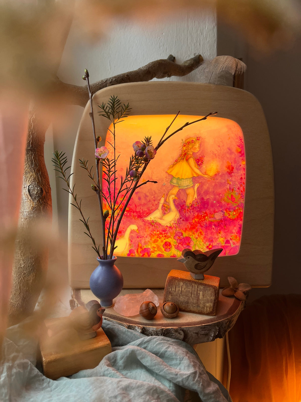 Toverlux Motiv Kleines Gänsemädchen von Anne Illustraties: leuchtende Lampe hinter Zweigen und einer kleinen Vase