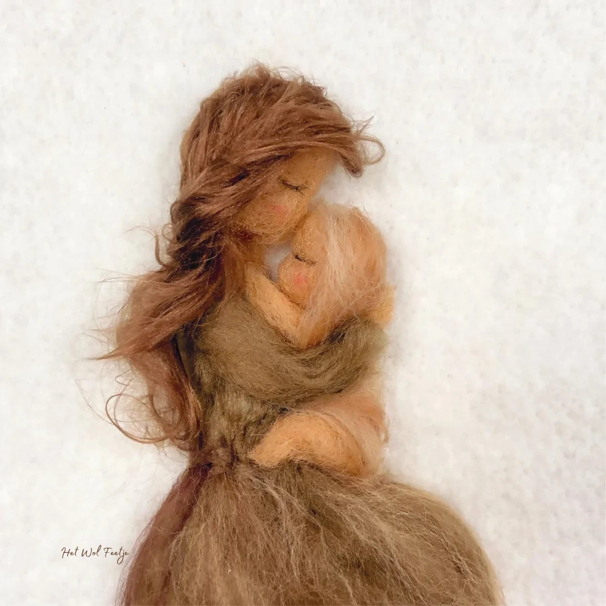 Toverlux Motiv Mutterliebe von Het Wol Feetje, Illustration: Gefilzte Mutter hält ihr Kind im Arm