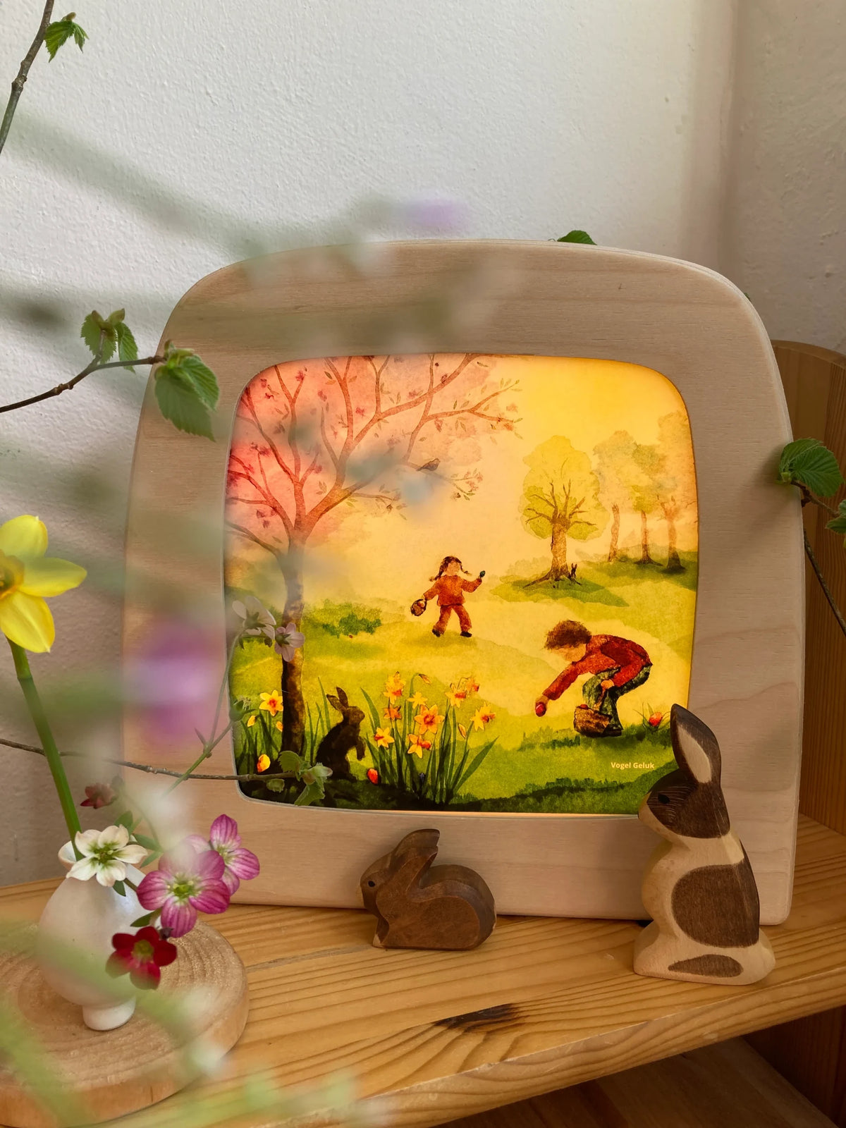 Toverlux Motiv Osterentdeckungen von Vogel Geluk: leuchtende Lampe hinter unscharfen Frühlingsblüten