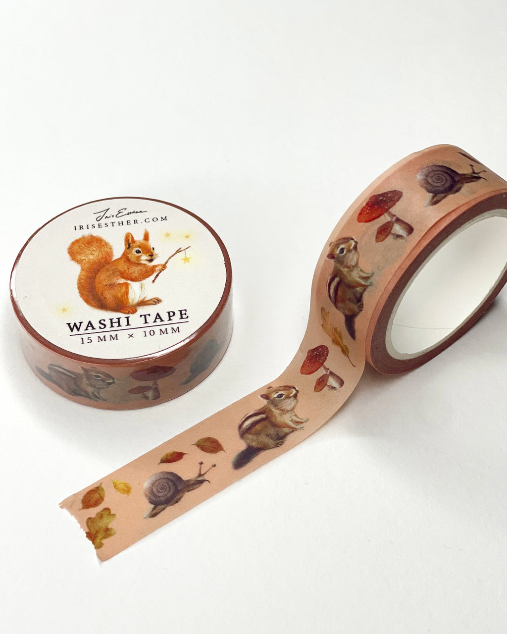Washi Tape Verzauberter Wald von Iris Esther, Rolle mit abgerolltem Band, Streifenhörnchen, Schnecken, Fliegenpilze und Herbstlaub auf zartem Rosa